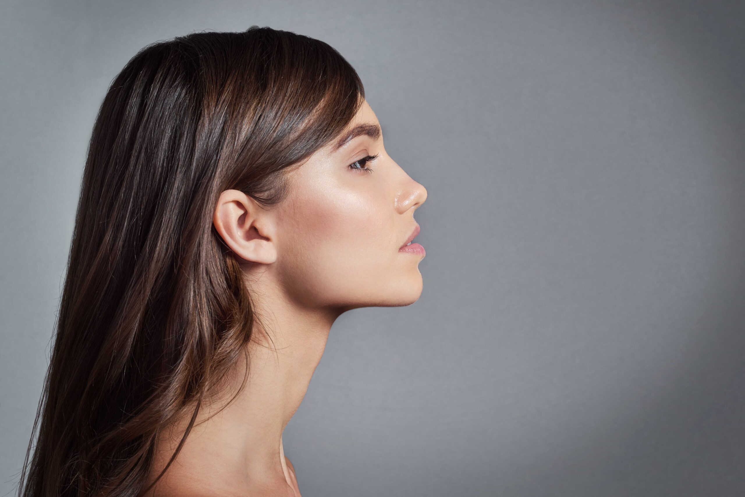 Clinician applying treatment to woman's eyebrow
