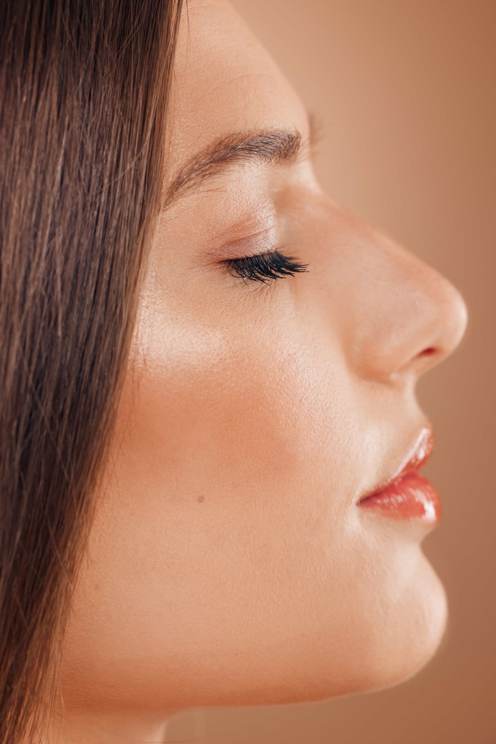 Side profile close-up of a young woman's face with light makeup, emphasizing the aesthetic alignment of the nose, forehead, and chin.