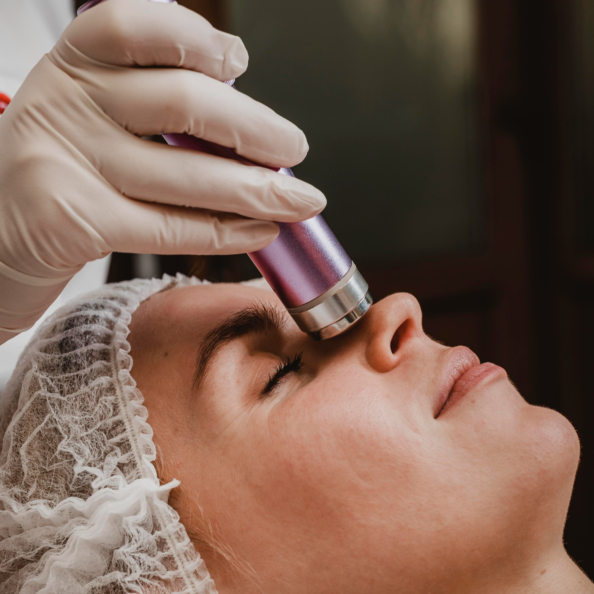 Woman having laser hair removal procedure performed on face