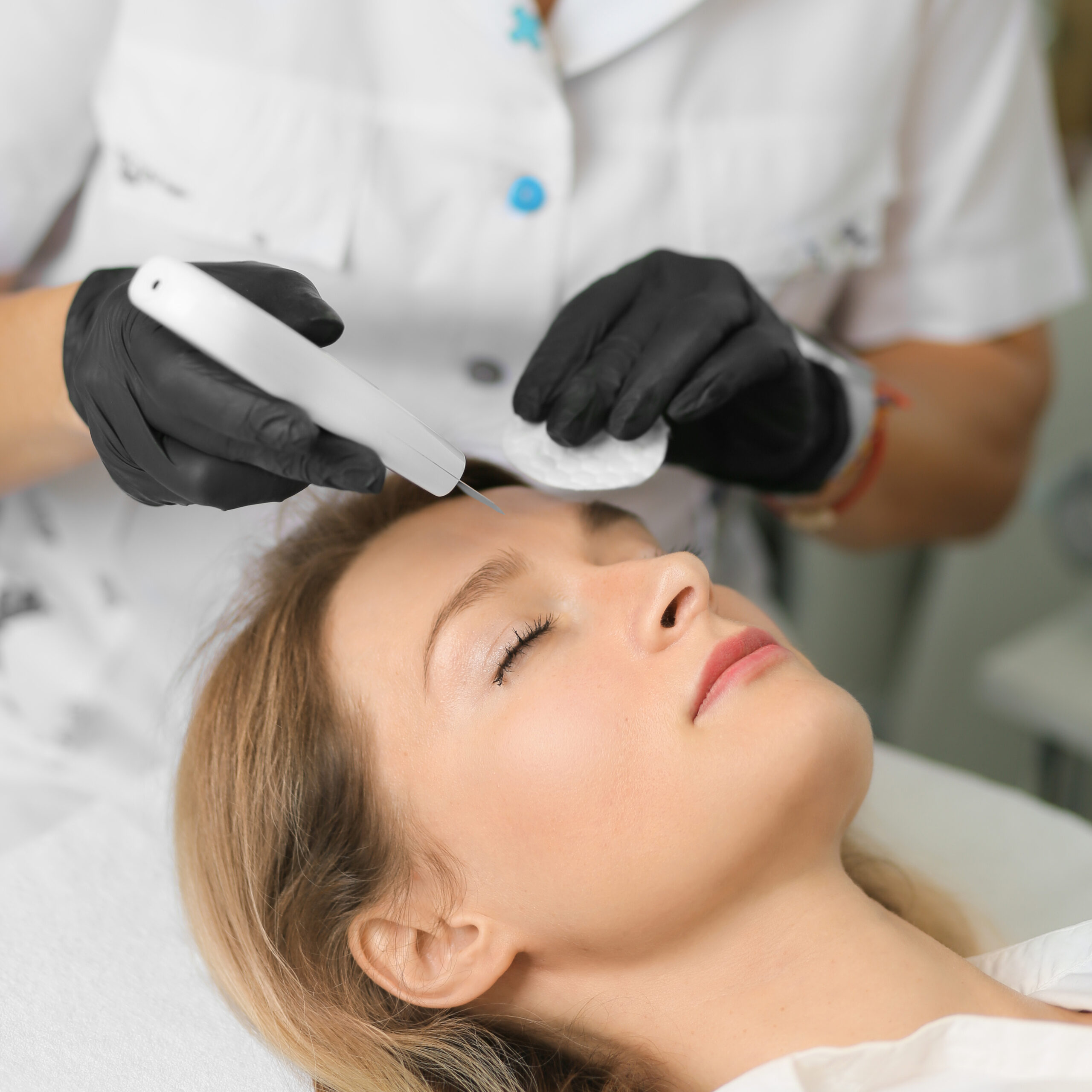 Woman having laser hair removal procedure performed on face