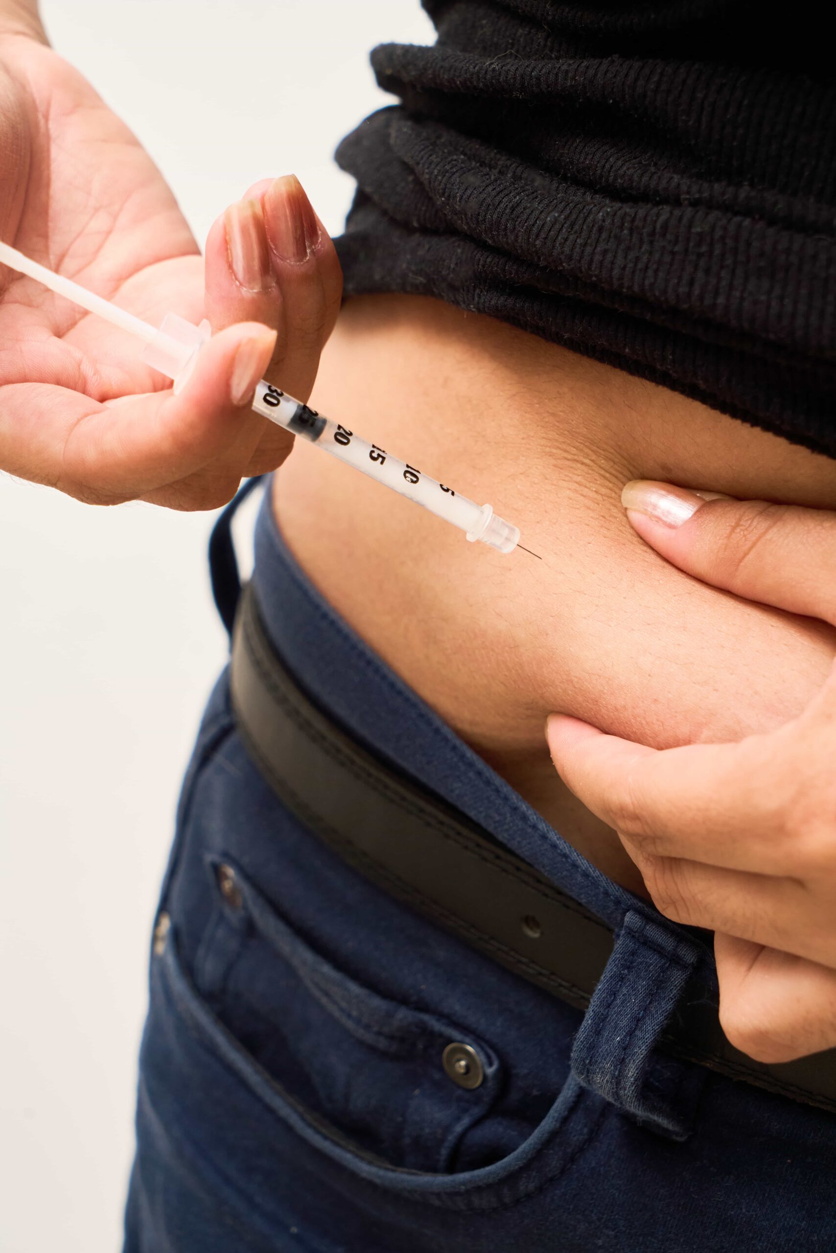 a diabetic young woman using insulin in stomach