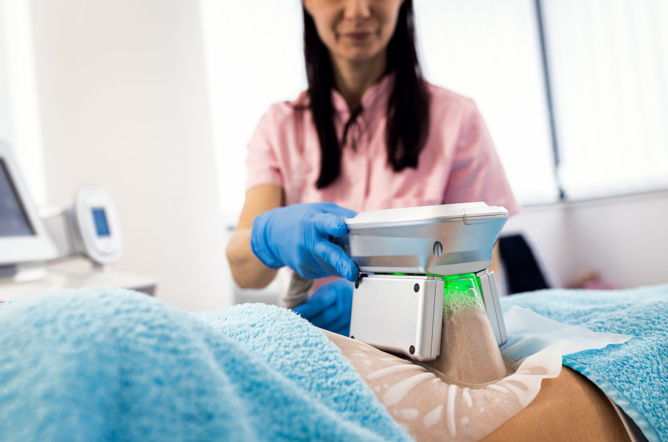 Beautician therapist applying cryolipolysis treatment in beauty