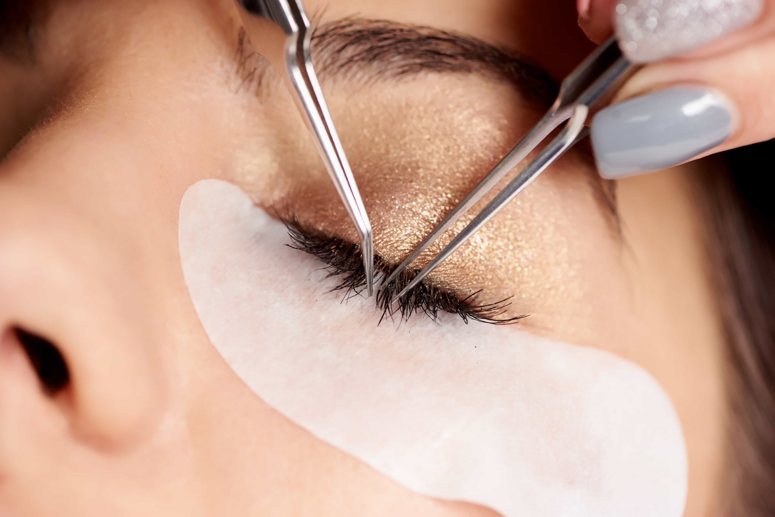 brunette woman is getting eyelash extensions