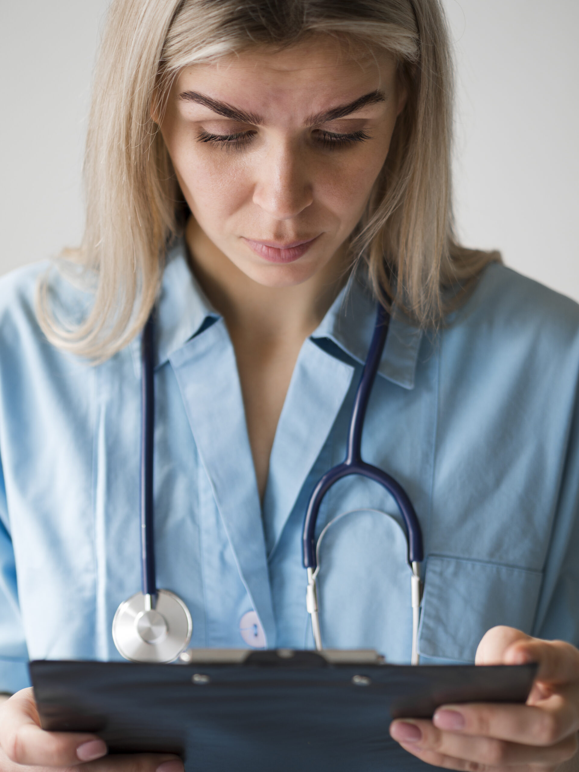 Concerned doctor looking at data device