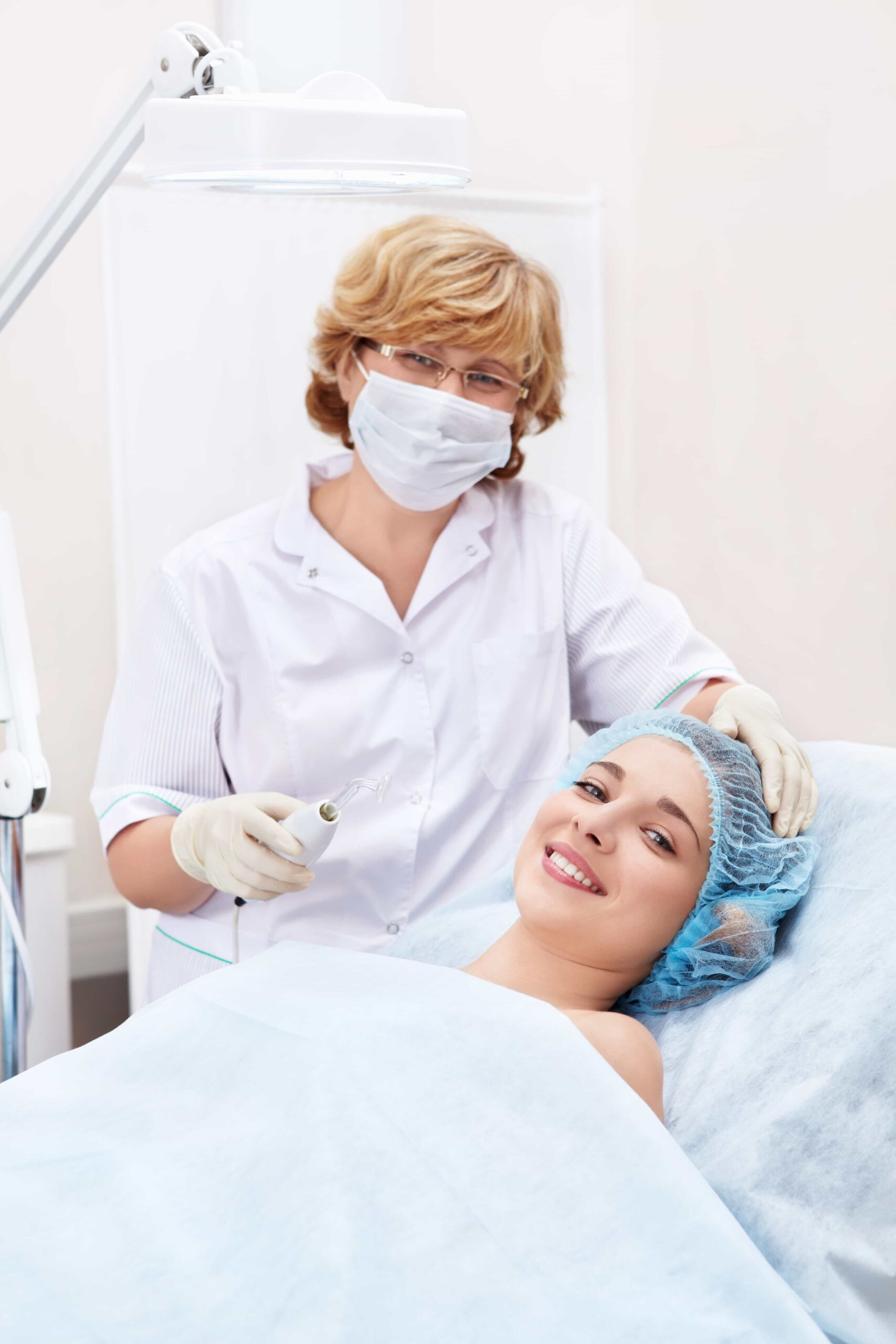 Female medical professional with mask on, putting on gloves