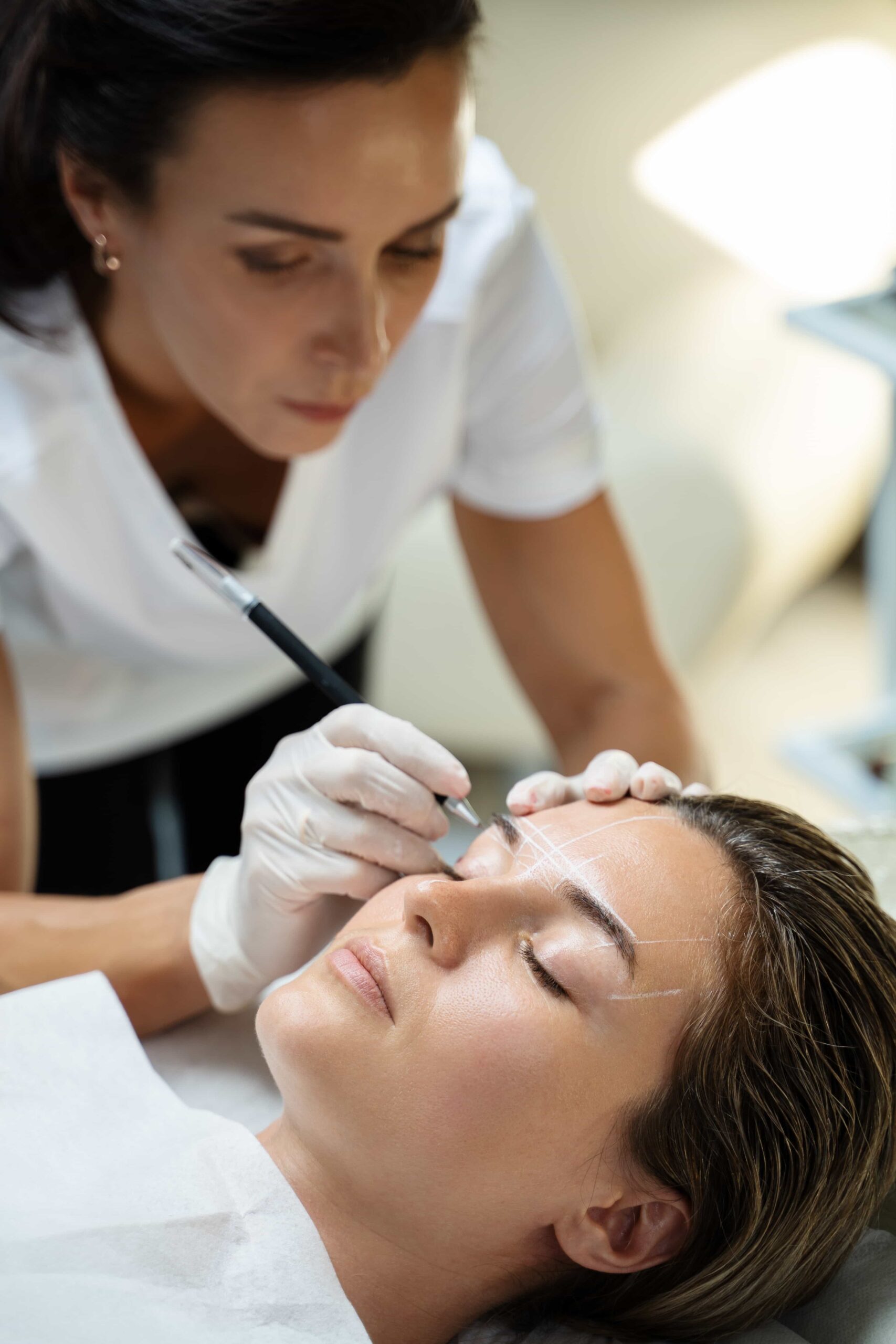 the permanent makeup artist draws a white outline
