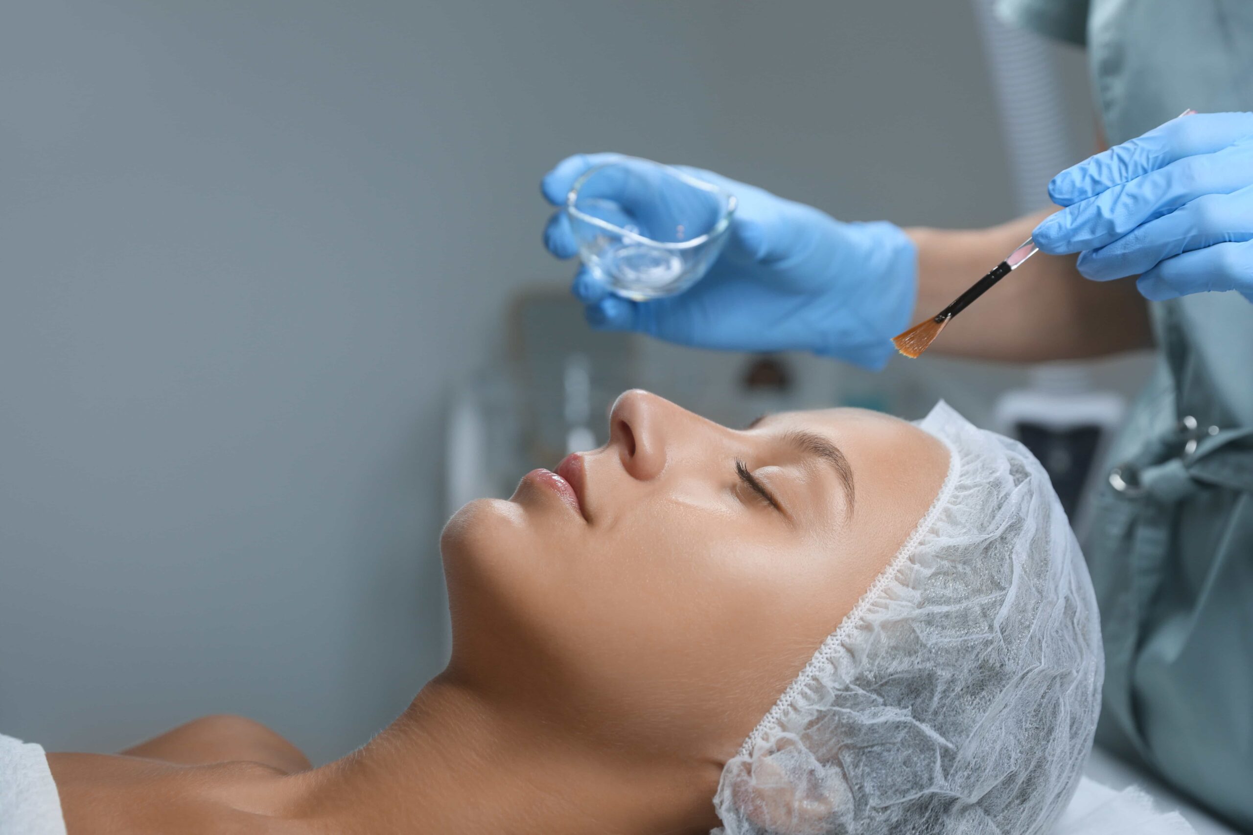 Cosmologist applying chemical peel to good looking woman